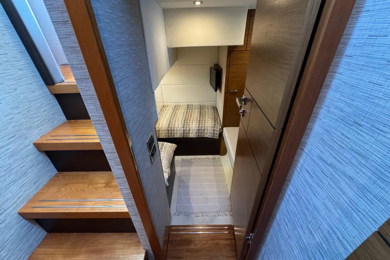 Slide: The Image of 2016 Tiara Yachts C44 Coupe cabin interior with wooden stairs and cozy bedding. - 58