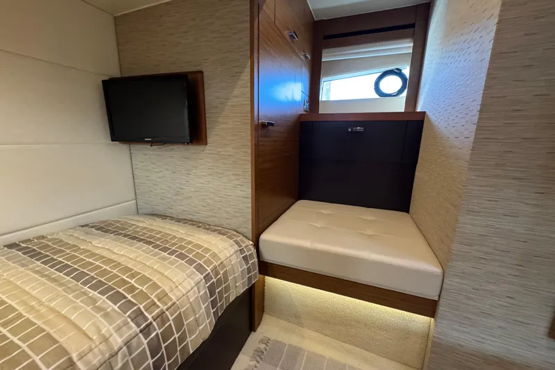 Slide: The Image of 2016 Tiara Yachts C44 Coupe interior cabin with bed, TV, and window. - 61
