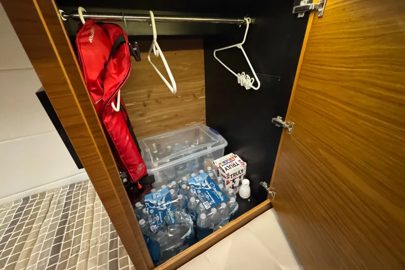 Slide: The Image of Storage closet in 2016 Tiara Yachts C44 Coupe with water bottles and life jacket. - 63