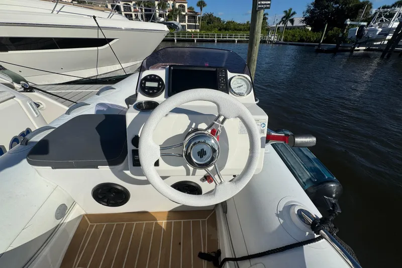 Slide: The Image of Helm of 2016 Tiara Yachts C44 Coupe with white steering wheel and navigation instruments. - 68