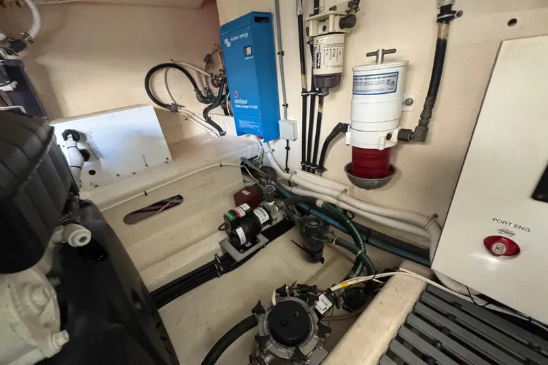 Slide: The Image of Engine room of 2016 Tiara Yachts C44 Coupe, featuring battery charger and fuel filter system. - 85