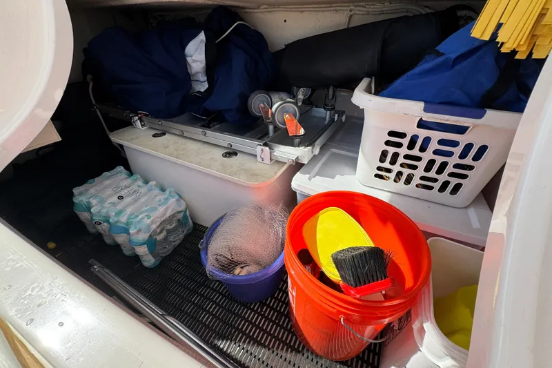 Slide: The Image of Storage area of a 2016 Tiara Yachts C44 Coupe with cleaning supplies and water bottles. - 95