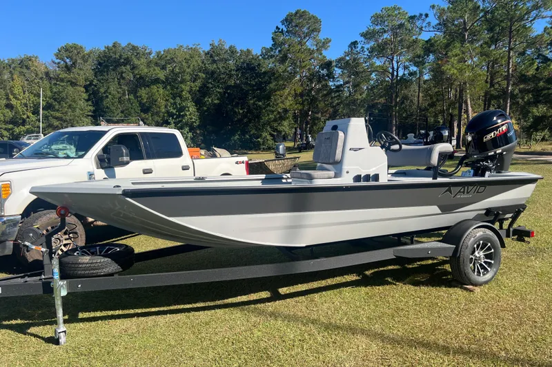 Slide: The Image of 2026 Avid 18 Rogue CC boat on trailer, parked outdoors near a white truck. - 2