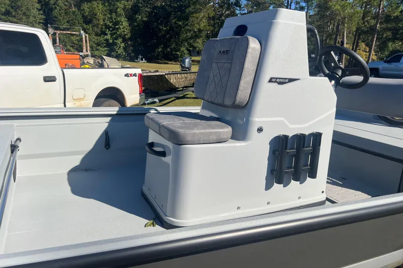 Slide: The Image of Avid 18 Rogue CC 2026 boat console with seating, parked near a white truck. - 9