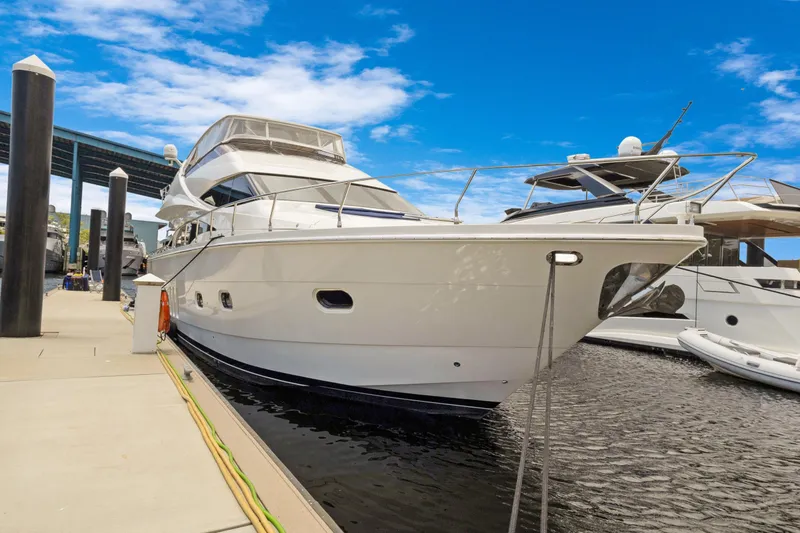 Slide: The Image of Luxury 2008 Marquis 690 yacht docked at marina under clear blue sky. - 1