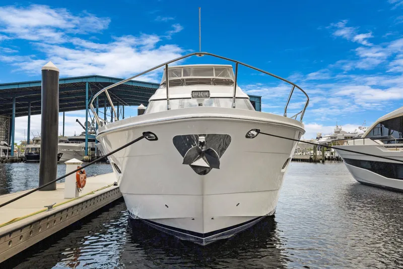 Slide: The Image of Front view of a 2008 Marquis 690 yacht docked at a marina. - 2