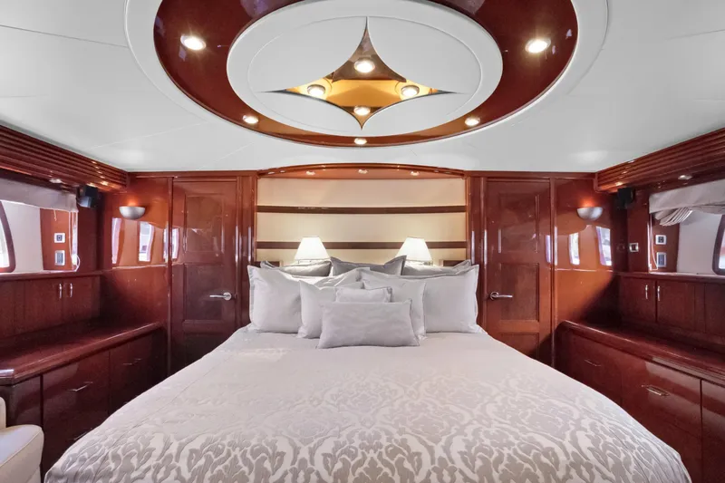 Slide: The Image of Luxurious 2008 Marquis 690 yacht bedroom with elegant wood finishes and plush bedding. - 25