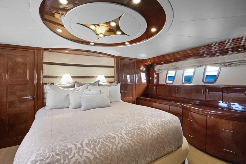 Slide: The Image of Luxurious 2008 Marquis 690 yacht bedroom with elegant wood finishes and plush bedding. - 27