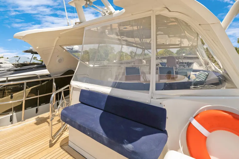 Slide: The Image of 2008 Marquis 690 yacht deck with seating, life preserver, and clear enclosure under blue sky. - 45