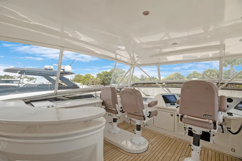Slide: The Image of 2008 Marquis 690 yacht helm with three captain chairs and navigation equipment. - 49