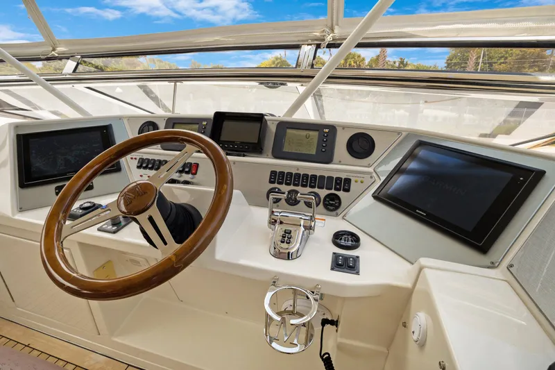 Slide: The Image of 2008 Marquis 690 yacht helm with steering wheel, navigation screens, and control panel. - 51