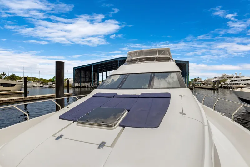 Slide: The Image of 2008 Marquis 690 yacht docked at marina under clear blue sky. - 54