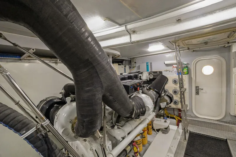 Slide: The Image of Engine room of a 2008 Marquis 690 yacht, featuring complex machinery and piping. - 61