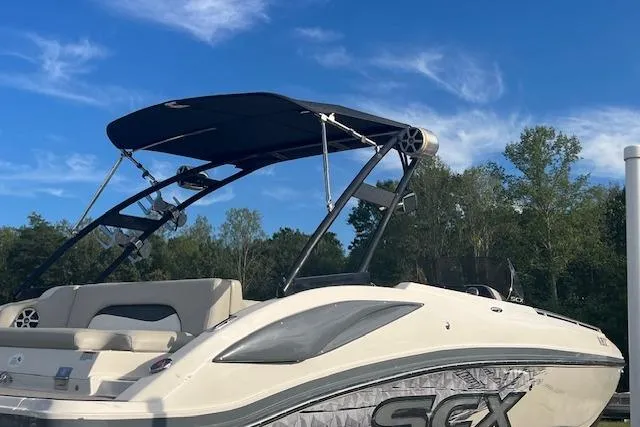 The Image of 2016 Starcraft Crossover 231 SCX IO SURF boat with canopy against blue sky. - 1