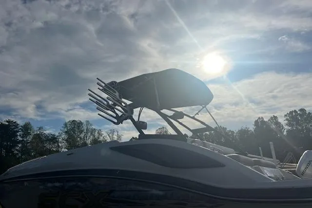 Slide: The Image of 2016 Starcraft Crossover 231 SCX IO SURF boat under a cloudy sky with sun. - 3