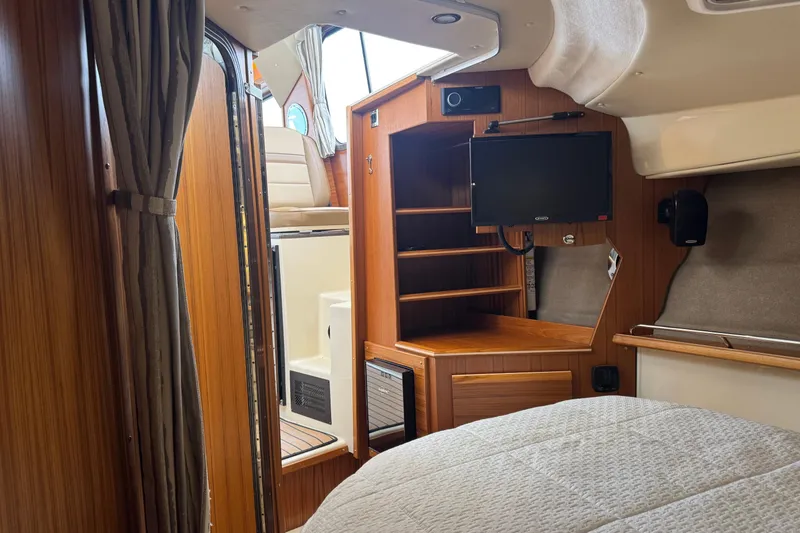 Slide: The Image of 2024 Ranger Tugs R-29 S cabin interior with cozy bed and wooden finish. - 12