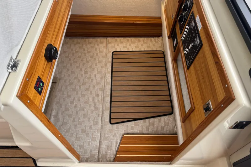 Slide: The Image of 2024 Ranger Tugs R-29 S interior with wooden table, beige seating, and nautical decor. - 16