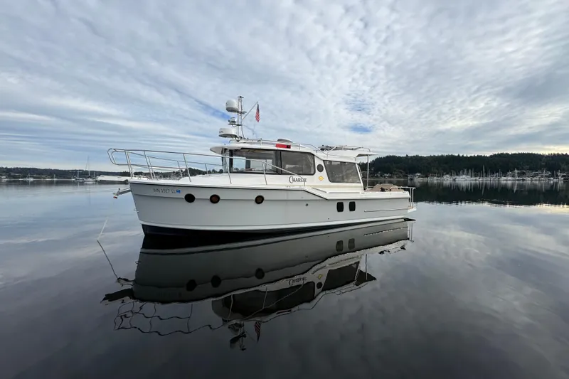 Slide: The Image of 2024 Ranger Tugs R-29 S docked at a marina under clear blue skies. - 2