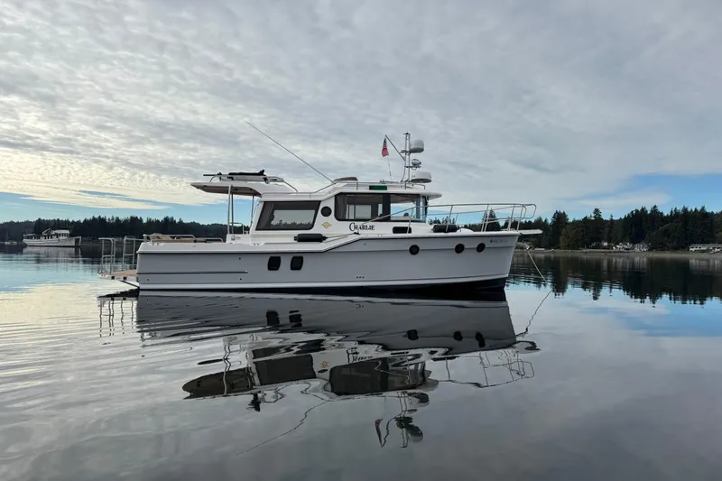 Slide: The Image of 2024 Ranger Tugs R-29 S boat on calm water with scenic background. - 23