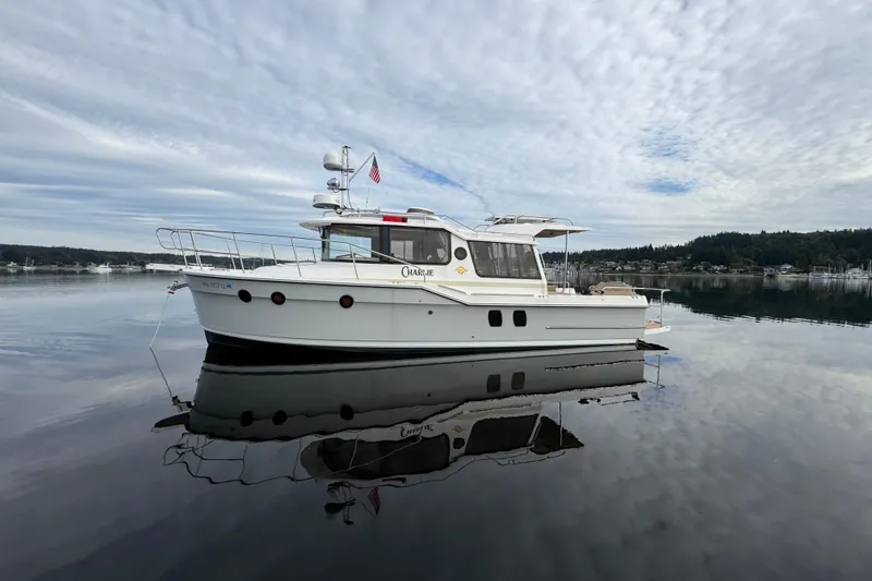 Slide: The Image of 2024 Ranger Tugs R-29 S boat on calm water under cloudy sky. - 26