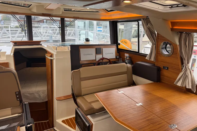 Slide: The Image of 2024 Ranger Tugs R-29 S docked at marina, sunny day, sleek design. - 5