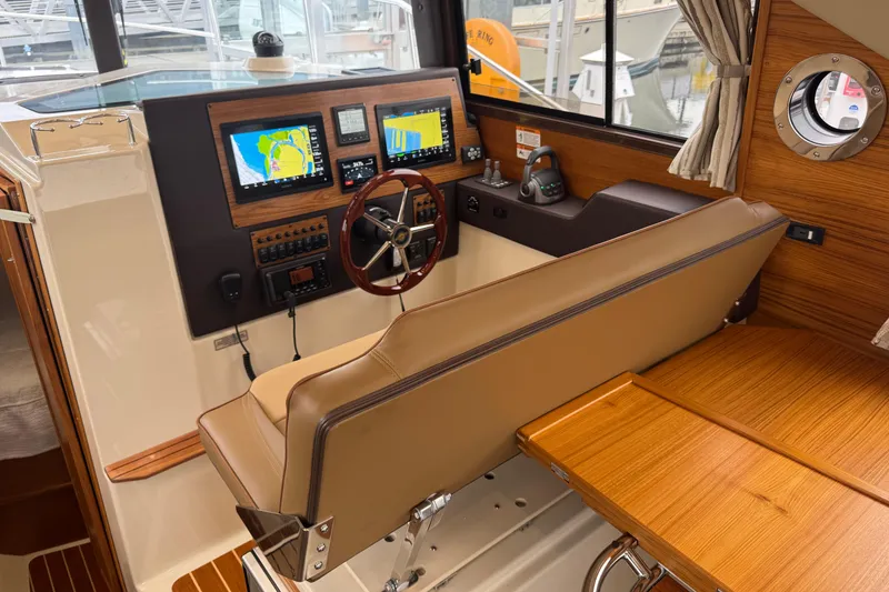 Slide: The Image of 2024 Ranger Tugs R-29 S interior with seating, kitchenette, and wood accents. - 7