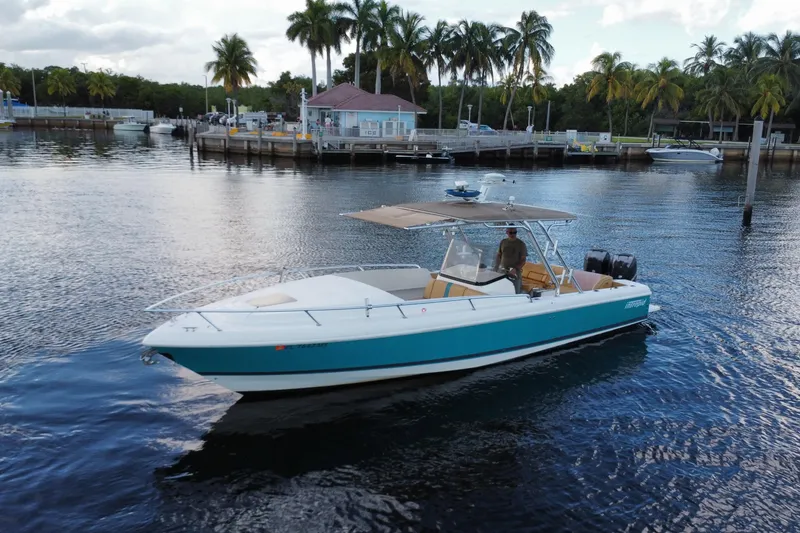 The Image of 2005 Intrepid 323 Cuddy boat on calm water near a tropical dock. - 0