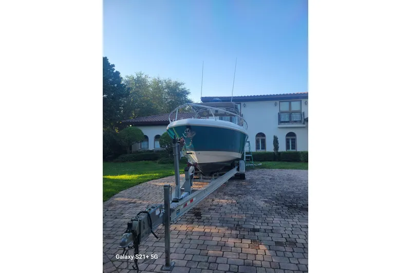 Slide: The Image of 2005 Intrepid 323 Cuddy boat on trailer in front of a house. - 11