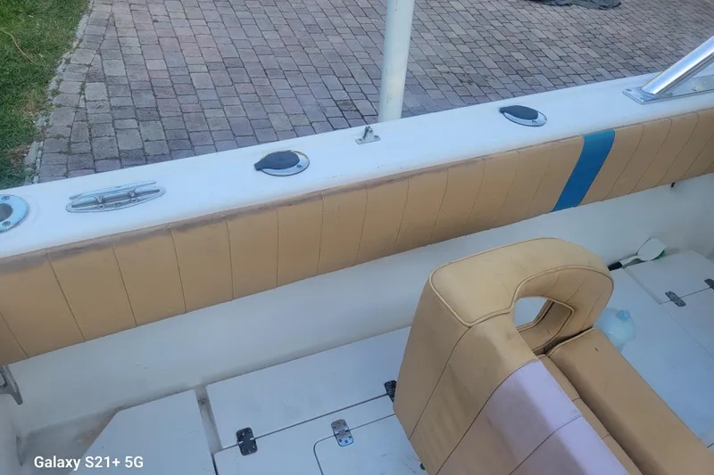 Slide: The Image of 2005 Intrepid 323 Cuddy boat interior with beige seating and deck details. - 33