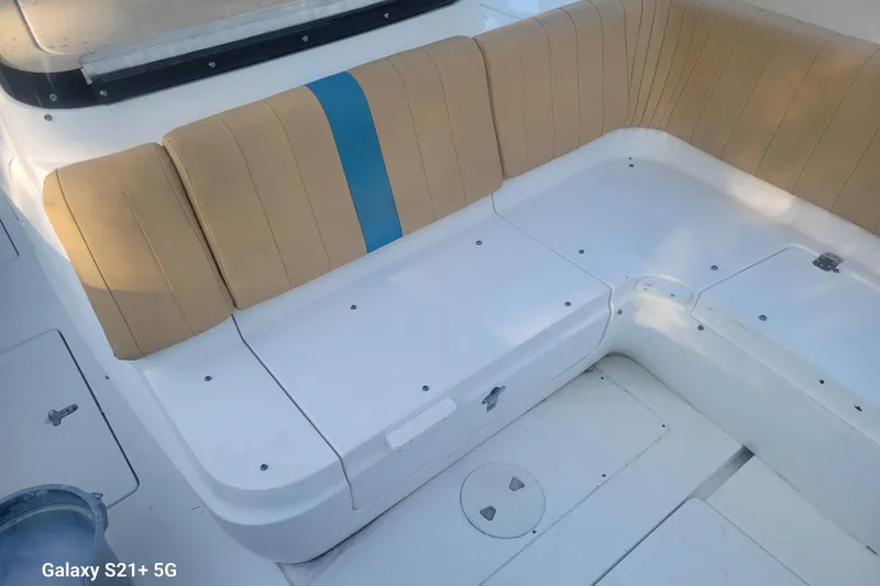Slide: The Image of 2005 Intrepid 323 Cuddy boat interior with tan and blue cushioned seating. - 38