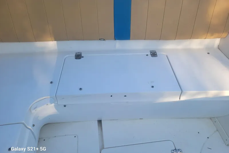Slide: The Image of 2005 Intrepid 323 Cuddy boat interior with white seating and storage compartment. - 40