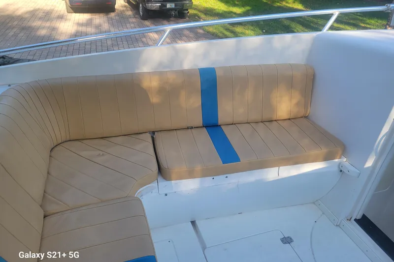 Slide: The Image of 2005 Intrepid 323 Cuddy boat interior with tan and blue cushioned seating. - 41
