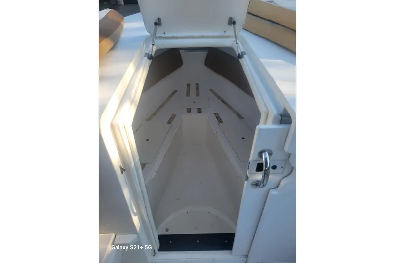 Slide: The Image of Open storage compartment of 2005 Intrepid 323 Cuddy boat, showcasing interior space. - 47