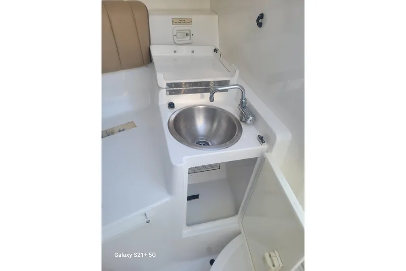 Slide: The Image of 2005 Intrepid 323 Cuddy boat interior with sink and storage area. - 55