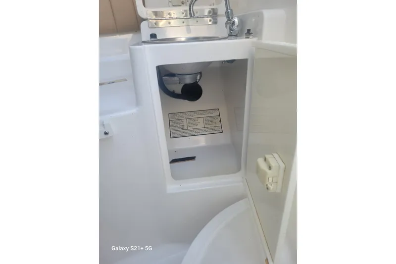 Slide: The Image of 2005 Intrepid 323 Cuddy interior sink and storage compartment. - 57