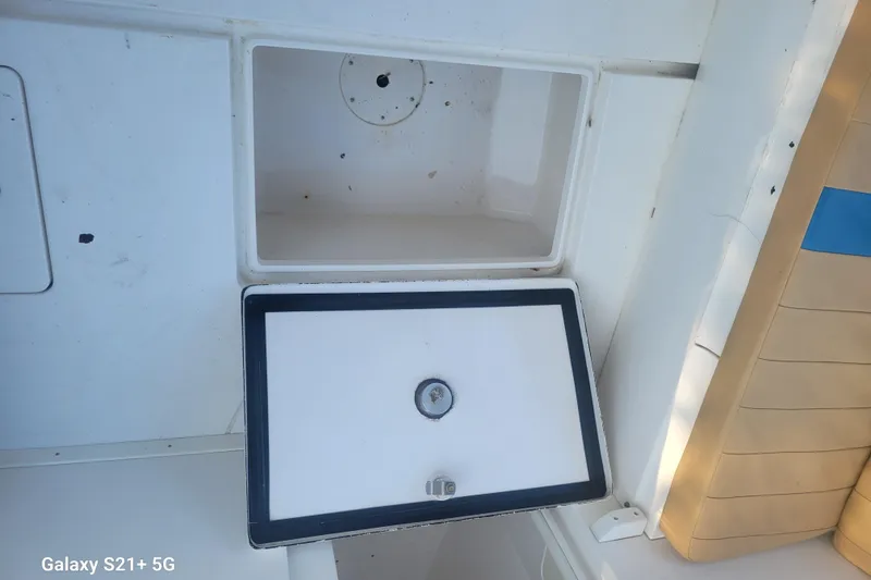 Slide: The Image of Open storage compartment on a 2005 Intrepid 323 Cuddy boat deck. - 58