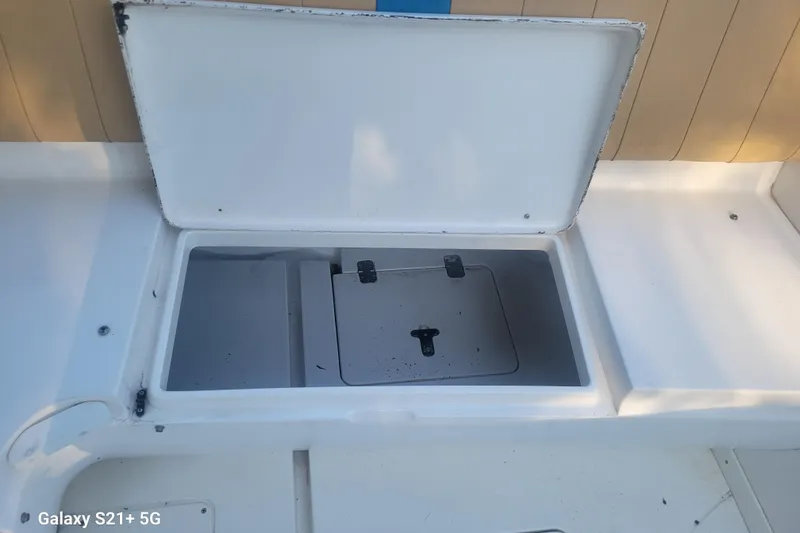 Slide: The Image of Open storage compartment on a 2005 Intrepid 323 Cuddy boat deck. - 59