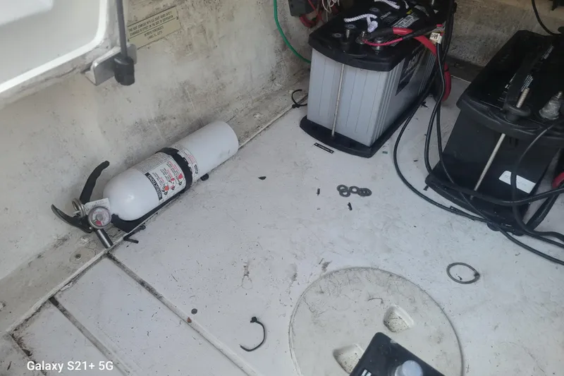 Slide: The Image of 2005 Intrepid 323 Cuddy boat interior with fire extinguisher and batteries. - 60