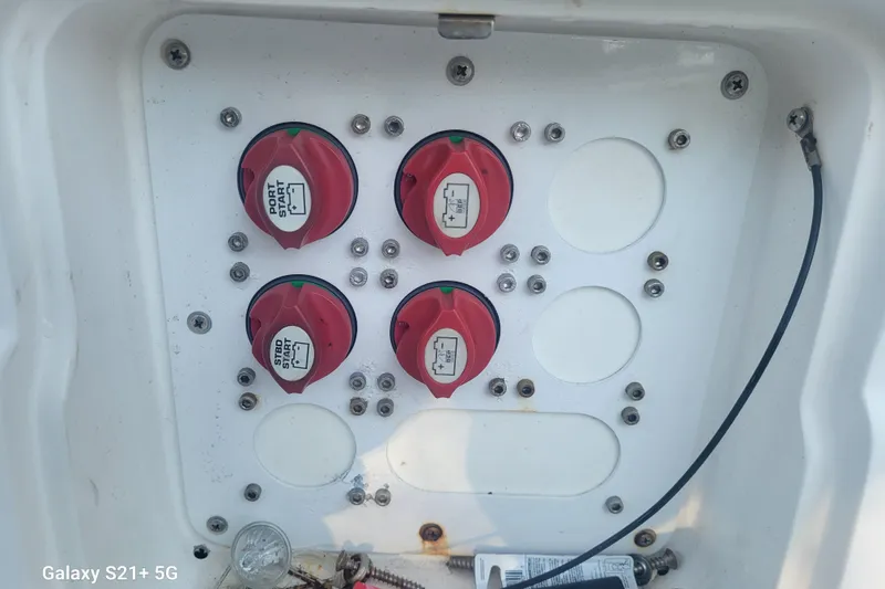 Slide: The Image of Battery switches on a 2005 Intrepid 323 Cuddy boat, featuring red dials and wiring. - 64