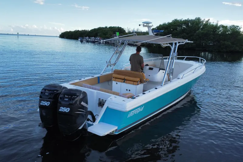 Slide: The Image of 2005 Intrepid 323 Cuddy boat with dual Mercury engines on calm water. - 8