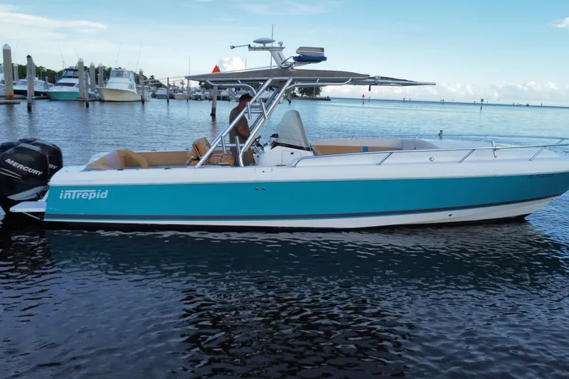 Slide: The Image of 2005 Intrepid 323 Cuddy boat with Mercury engine, docked in a marina. - 9