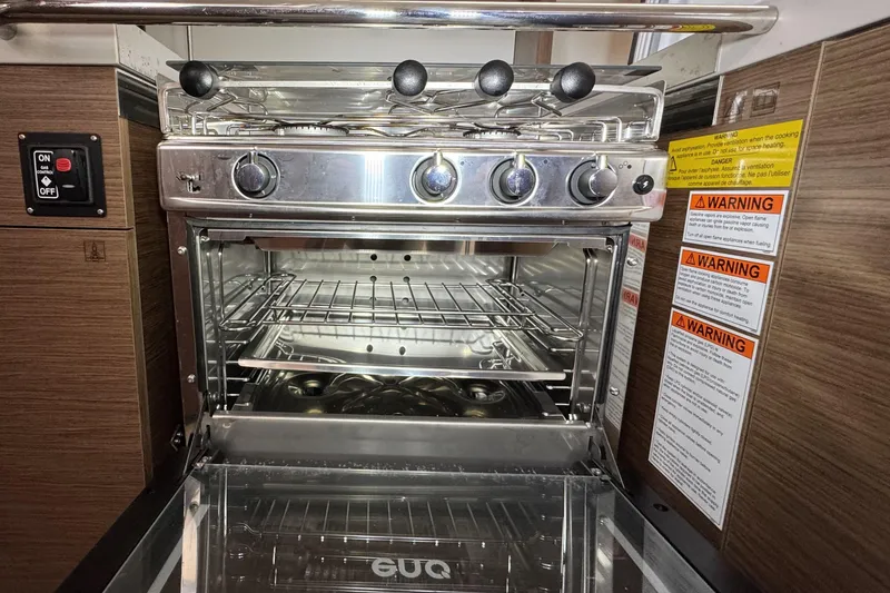 Slide: The Image of Stainless steel oven in 2022 Beneteau Oceanis 46.1 yacht kitchen, with safety warnings. - 20