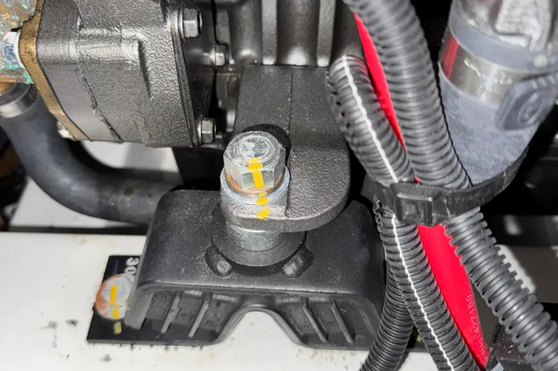 Slide: The Image of Engine component of a 2022 Beneteau Oceanis 46.1 sailboat, featuring bolts and wiring. - 27