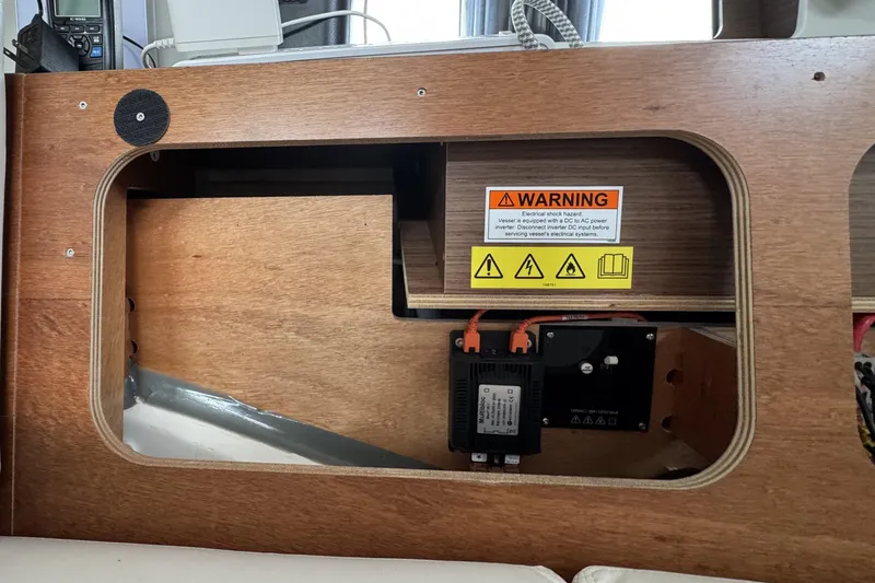Slide: The Image of Interior view of 2022 Beneteau Oceanis 46.1 showing electrical panel with warning label. - 29