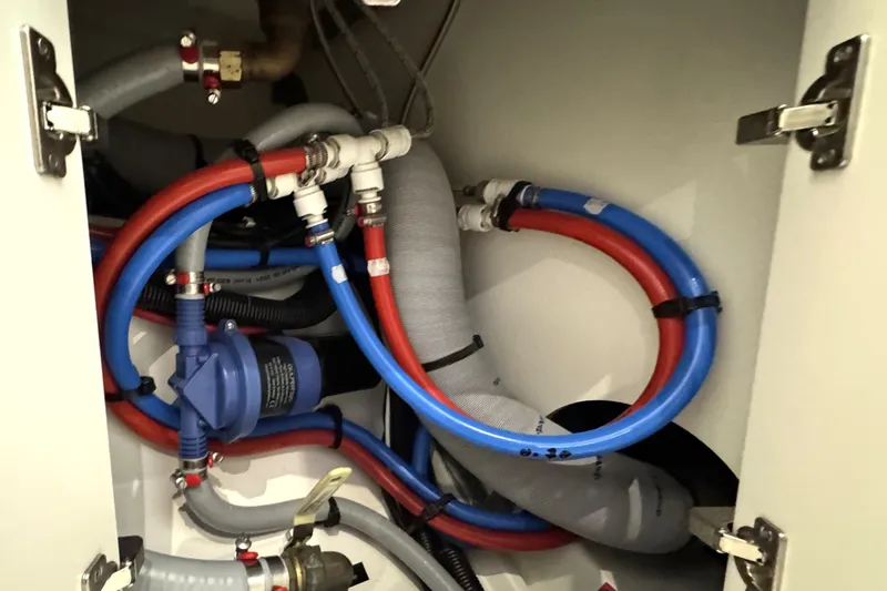 Slide: The Image of Plumbing system inside 2022 Beneteau Oceanis 46.1 yacht, featuring red and blue hoses. - 37