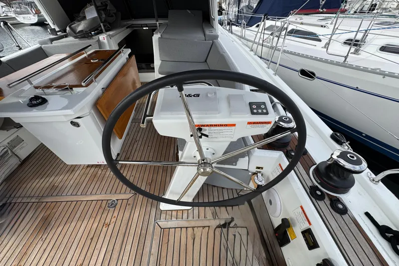 Slide: The Image of Cockpit of 2022 Beneteau Oceanis 46.1 yacht with steering wheel and navigation controls. - 53