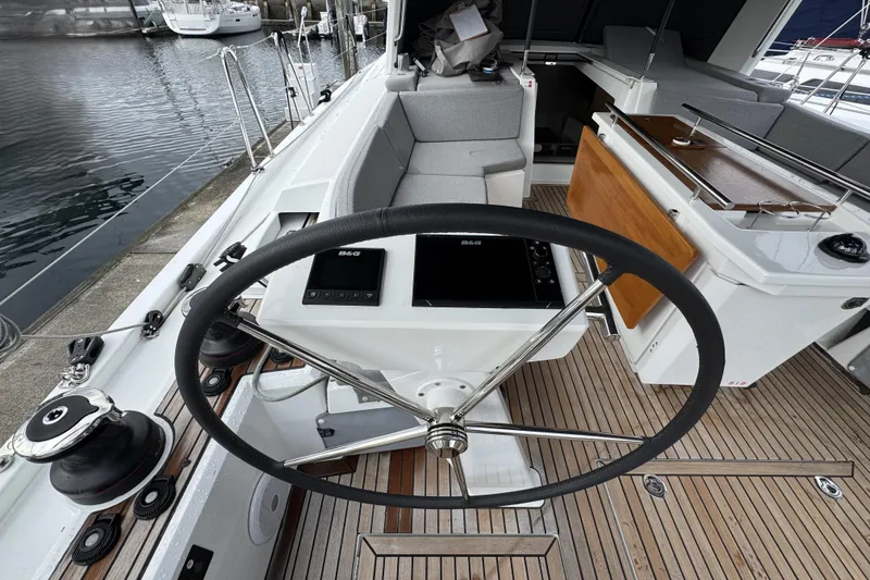 Slide: The Image of Steering wheel of 2022 Beneteau Oceanis 46.1 yacht, featuring modern navigation equipment. - 54