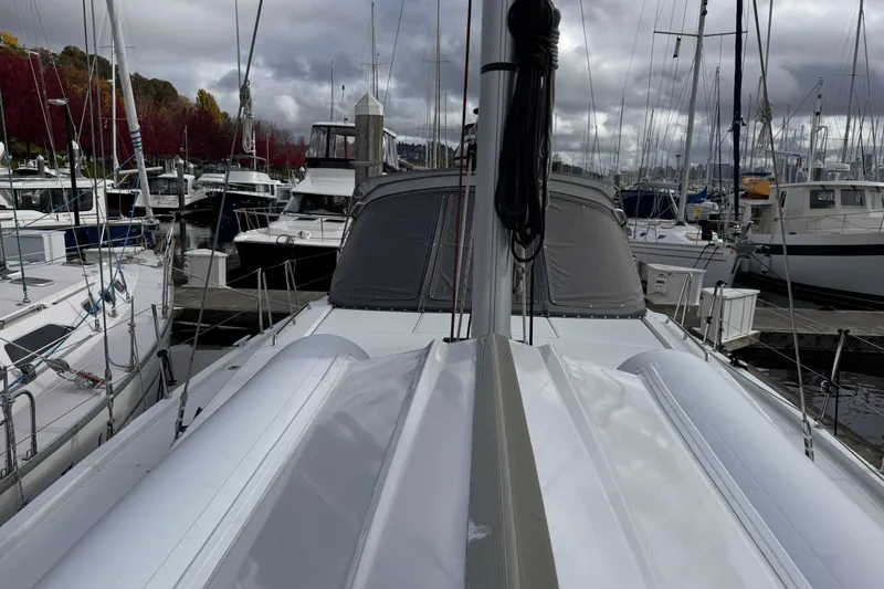 Slide: The Image of 2022 Beneteau Oceanis 46.1 sailboat docked in a marina, surrounded by other boats. - 60