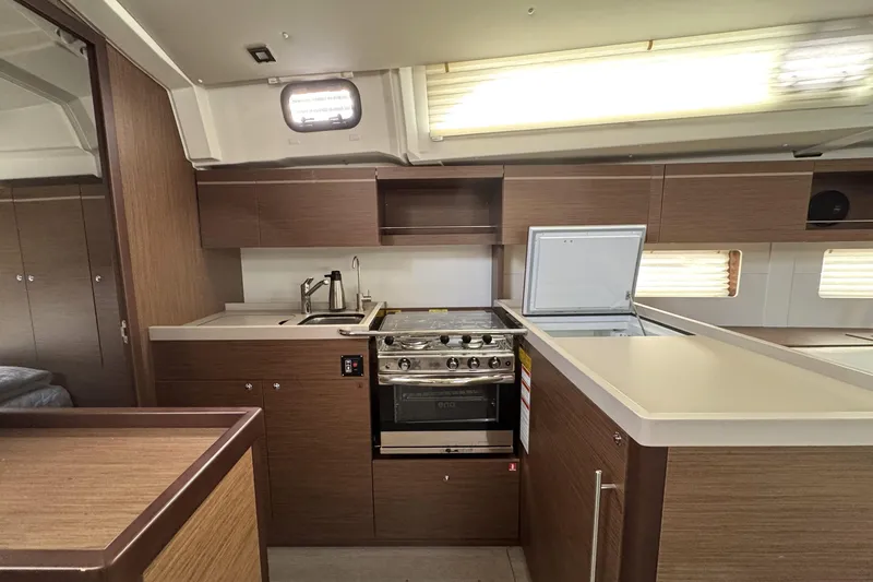 Slide: The Image of Modern kitchen interior of 2022 Beneteau Oceanis 46.1 yacht with wood cabinetry and appliances. - 8