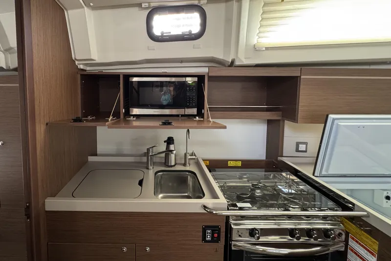Slide: The Image of Modern kitchen in 2022 Beneteau Oceanis 46.1 yacht with stove, sink, and microwave. - 9